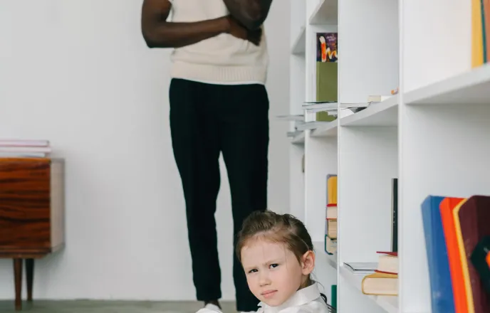 Niña sentada junto a una profesional en una consulta